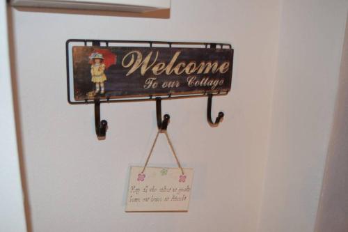 a welcome sign is hanging on a wall at Cecil's Cottage, Ballynary, Buncrana by Wild Atlantic Wanderer in Buncrana