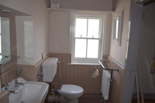 a bathroom with a toilet and a sink and a window at Cecil's Cottage, Ballynary, Buncrana by Wild Atlantic Wanderer in Buncrana