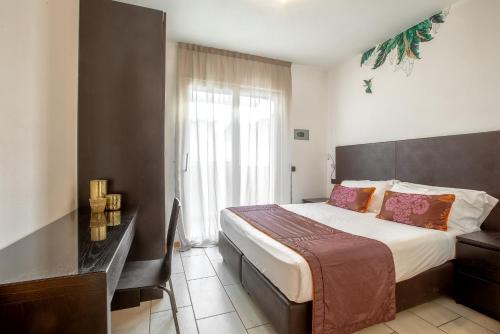 Un dormitorio con una cama grande y una ventana en Residenza D-Place Ponchielli, en Riccione