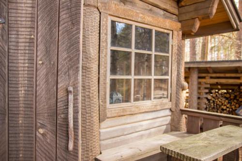 a wooden cabin with a window and a table at Herranniemi Guesthouse in Vuonislahti