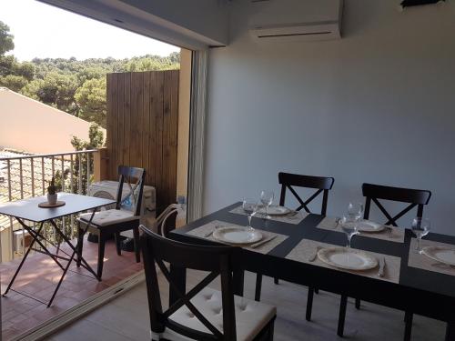 une salle à manger avec une table et des chaises sur un balcon dans l'établissement LA FRANQUI proche plage - vue mer - wifi - clim, à Leucate