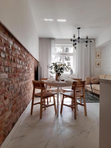 une salle à manger avec une table et un mur en briques dans l'établissement P79, à Olsztyn