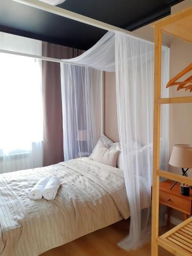 a bedroom with a canopy bed with two towels on it at P79 in Olsztyn