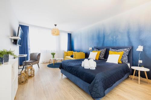 a blue bedroom with a bed and a blue wall at Apartamenty Rzemieślnicza 5 in Władysławowo