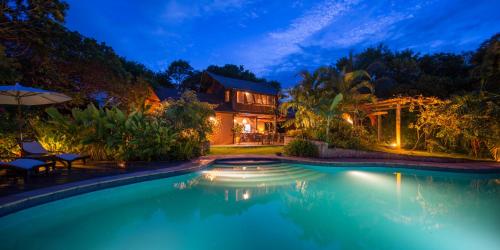 a house with a swimming pool at night at Pousada Mangabeiras in Ilha de Boipeba