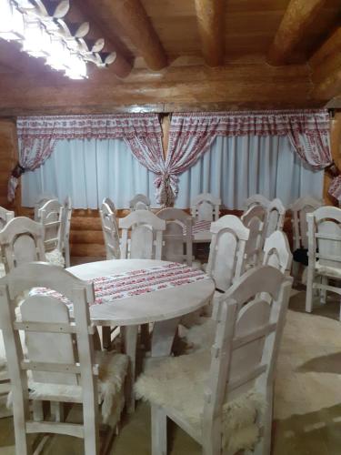 comedor con mesa blanca y sillas en Pensiunea Laricea, en Vatra Dornei