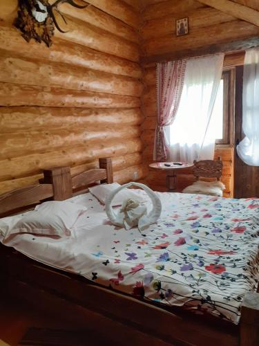 1 dormitorio con 1 cama en una cabaña de madera en Pensiunea Laricea, en Vatra Dornei