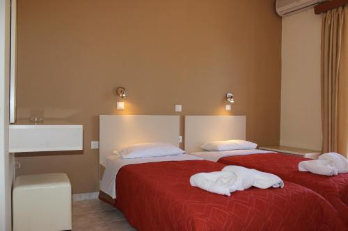 two beds in a bedroom with towels on them at Villa Melisti in Tsoukaladhes