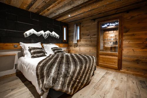 ein Schlafzimmer mit einem Bett in einem Blockhaus in der Unterkunft Les Mazots des Fées in Morzine