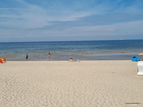 a group of people on a beach with the ocean at Apartamenty ApartPark - visitopl in Świnoujście