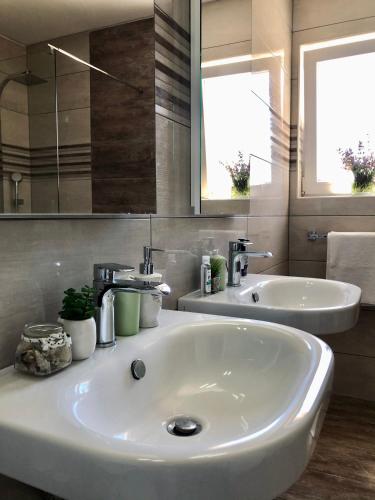 a bathroom with a white sink and a mirror at Villa Dora - Mediterranean family house for 9 with private garden, BBQ, sea view and private parking for 4 cars in Pag