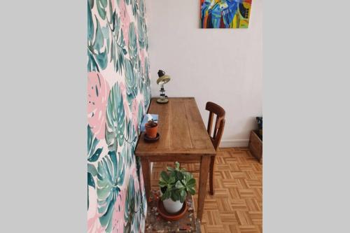 a dining room with a table and a plant at Le Réverbère - coeur urbain d'Epernay in Épernay