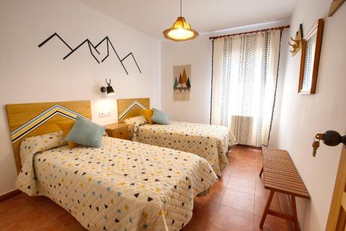 ein Hotelzimmer mit zwei Betten und einem Tisch in der Unterkunft Cuencaloft La casa del tío Serafín in Cuenca