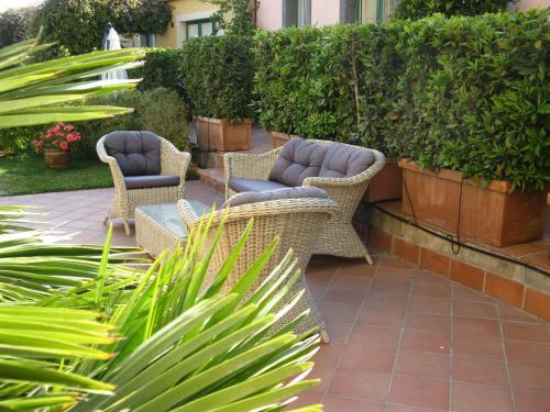 a patio with wicker chairs and plants at Torre Archirafi Resort in Riposto