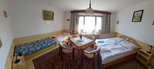 a living room with a table and chairs and a bed at Pension MAAN in Tatranska Strba