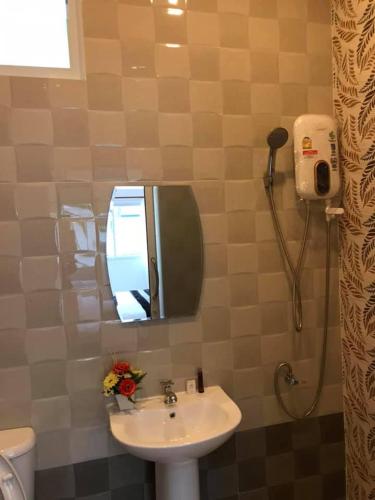 a bathroom with a sink and a mirror and a shower at นิวเวฟภูเก็ต in Ban Na Kok