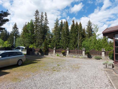 a car parked in a driveway next to a fence at Pension MAAN in Tatranska Strba