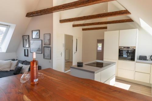 a kitchen with white cabinets and a wooden table at Ankerplatz in Tönning