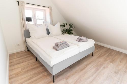 a bedroom with a white bed with towels on it at Ankerplatz in Tönning