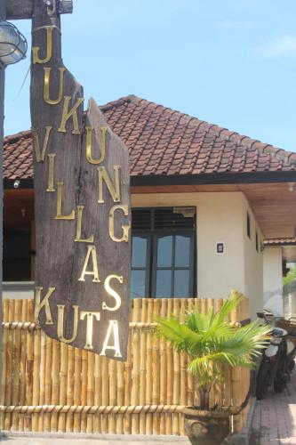 a sign for a hotel in front of a house at Jukung Villas Kuta in Kuta