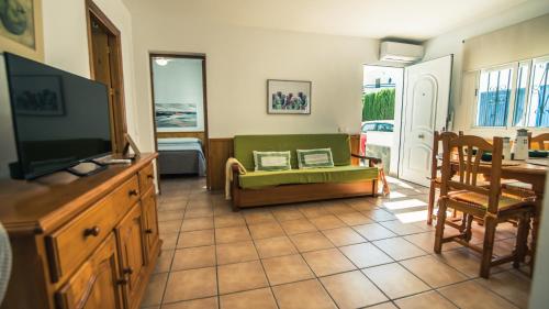 a living room with a television and a couch at Casa Coral - San José in San José
