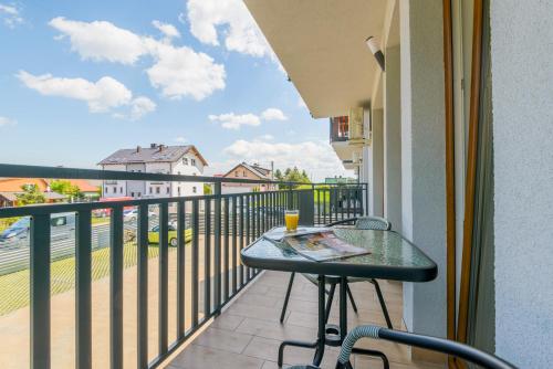 a balcony with a table with a drink on it at APARTAMENTY PIAMOLA Willa Zacisze Kąty Rybackie in Kąty Rybackie