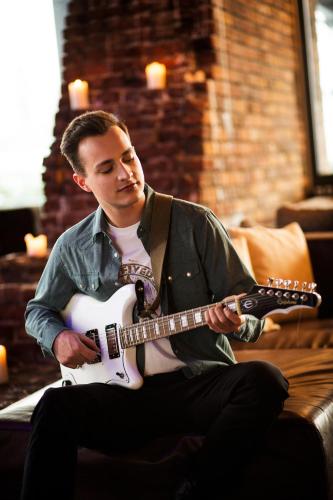 a man sitting on a couch playing a guitar at pentahotel Wiesbaden in Wiesbaden