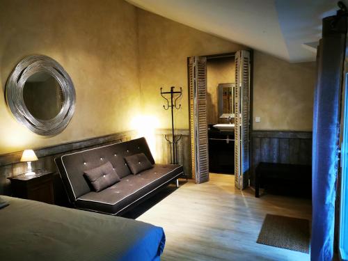 a living room with a couch and a mirror at Le Puits de la Foltière in Azay-sur-Cher