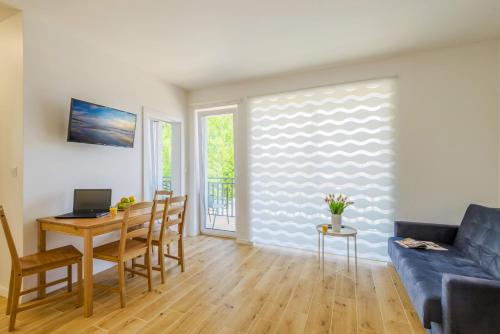 a living room with a blue couch and a table at APARTAMENTY PIAMOLA Willa Zacisze Kąty Rybackie in Kąty Rybackie