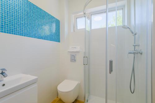 a bathroom with a shower and a toilet and a sink at APARTAMENTY PIAMOLA Willa Zacisze Kąty Rybackie in Kąty Rybackie