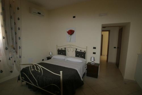 a bedroom with a bed with a red flower on the wall at Tavernola - Locanda Di Campagna in Battipaglia