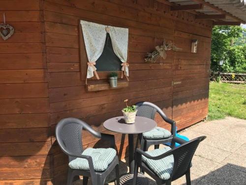 a patio with three chairs and a table in a building at Pension Horvath in Sankt Kanzian