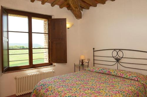 a bedroom with a bed and a large window at Castello di Modanella in Rapolano Terme