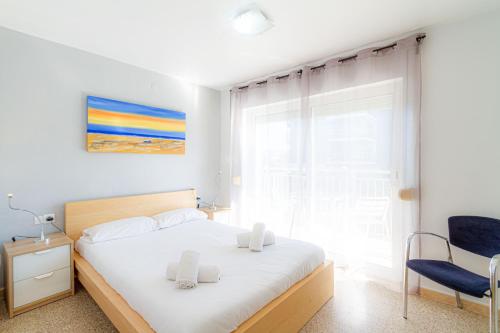 een slaapkamer met een bed, een stoel en een raam bij Residencial Costamar next Bcn, 50m beach with swimmingpool in Cabrera de Mar