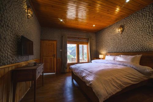 a bedroom with a large bed and a window at Roomy Daastaan Hotel, Karimabad Hunza in Hunza