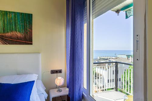 1 dormitorio con ventana y vistas al océano en Apartment Llavaneres II, en Sant Andreu de Llavaneres