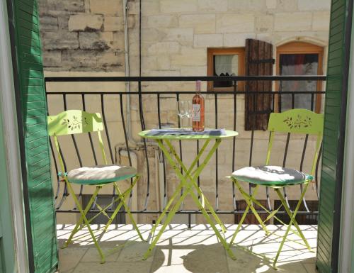 une table et deux chaises assises sur un balcon dans l'établissement Maison Le Petit Balcon Beaucaire, à Beaucaire