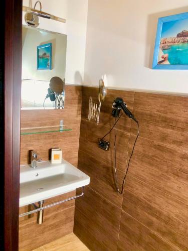 a bathroom with a sink and a camera on the wall at Cuore Della Valle in Cefalù