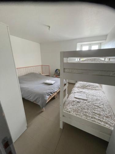 a bedroom with two bunk beds and a window at Le petit écrin champenois in Étoges