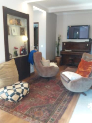 a living room with two chairs and a couch at Traditional Villa In S Pedro , ESTORIL in Alapraia
