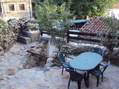 a table and chairs with a blue table and a bench at Artesano I y III in Navarredonda de Gredos