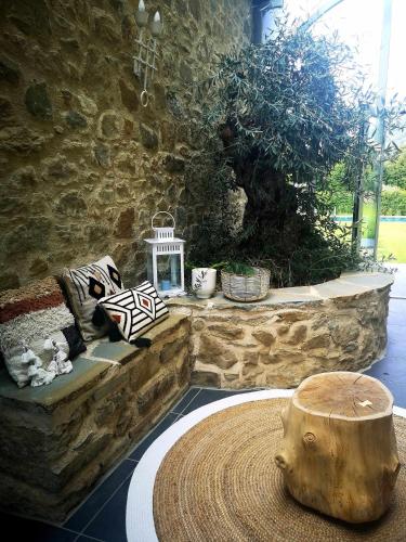 a room with a stone wall and a table with a log at Alba Morus Bed & Breakfast sentiti a casa nel cuo in Arezzo