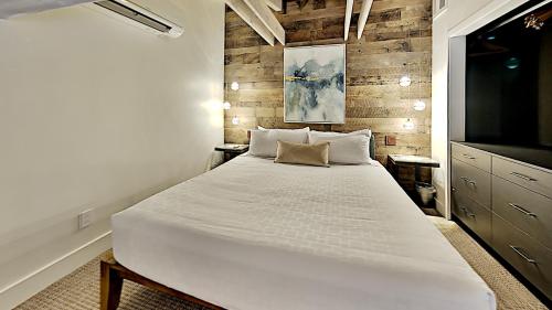 um quarto com uma grande cama branca e uma televisão em Timberline Condominiums Studio Loft Premier Unit 304 em Snowmass Village