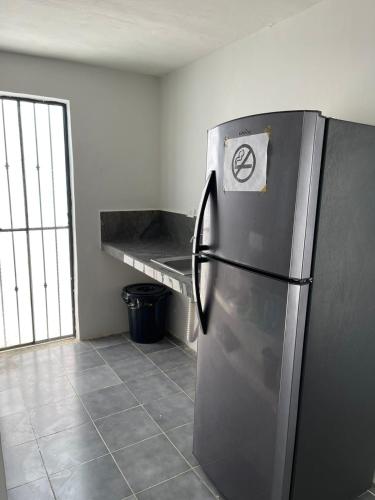 a kitchen with a stainless steel refrigerator with a sticker on it at Casa con Piscina en Chixchulub a 100 m de la playa in Chicxulub