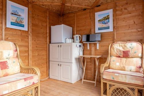a room with a refrigerator and two chairs and a table at Rockmount Court in Bournemouth