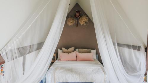 a white canopy bed with pink pillows on it at The Loft at 82 Cathedral with Parking in Cardiff