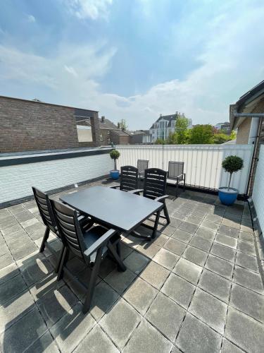 a patio with a table and chairs on a roof at Vakantieappartement Diepstraat in Eijsden
