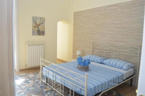 a bedroom with a bed with blue pillows at Duke's Rooms in Taranto