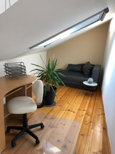 a living room with a couch and a table and a desk at Ferienwohnung Alte Molkerei in Bad Sulza