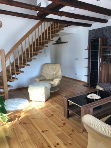 a living room with wooden floors and a staircase at Ferienwohnung Alte Molkerei in Bad Sulza